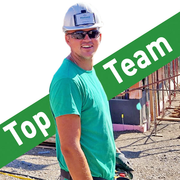Ein lächelnder Bauarbeiter auf der Baustelle, daneben steht "Top-Team"
